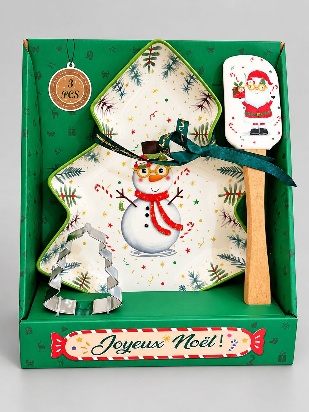 Coffret cadeau Snowman de Noël sur fond gris clair, avec plat sapin, spatule Père Noël et emporte-pièce en métal.