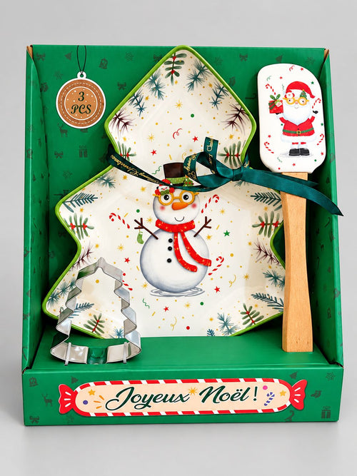 Coffret cadeau Snowman de Noël sur fond gris clair, avec plat sapin, spatule Père Noël et emporte-pièce en métal.
