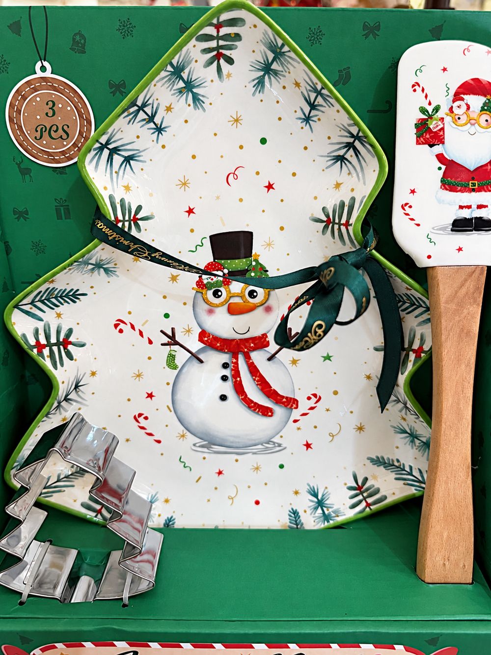 Détail du plat sapin au bonhomme de neige, de la spatule Père Noël et de l’emporte-pièce en métal.