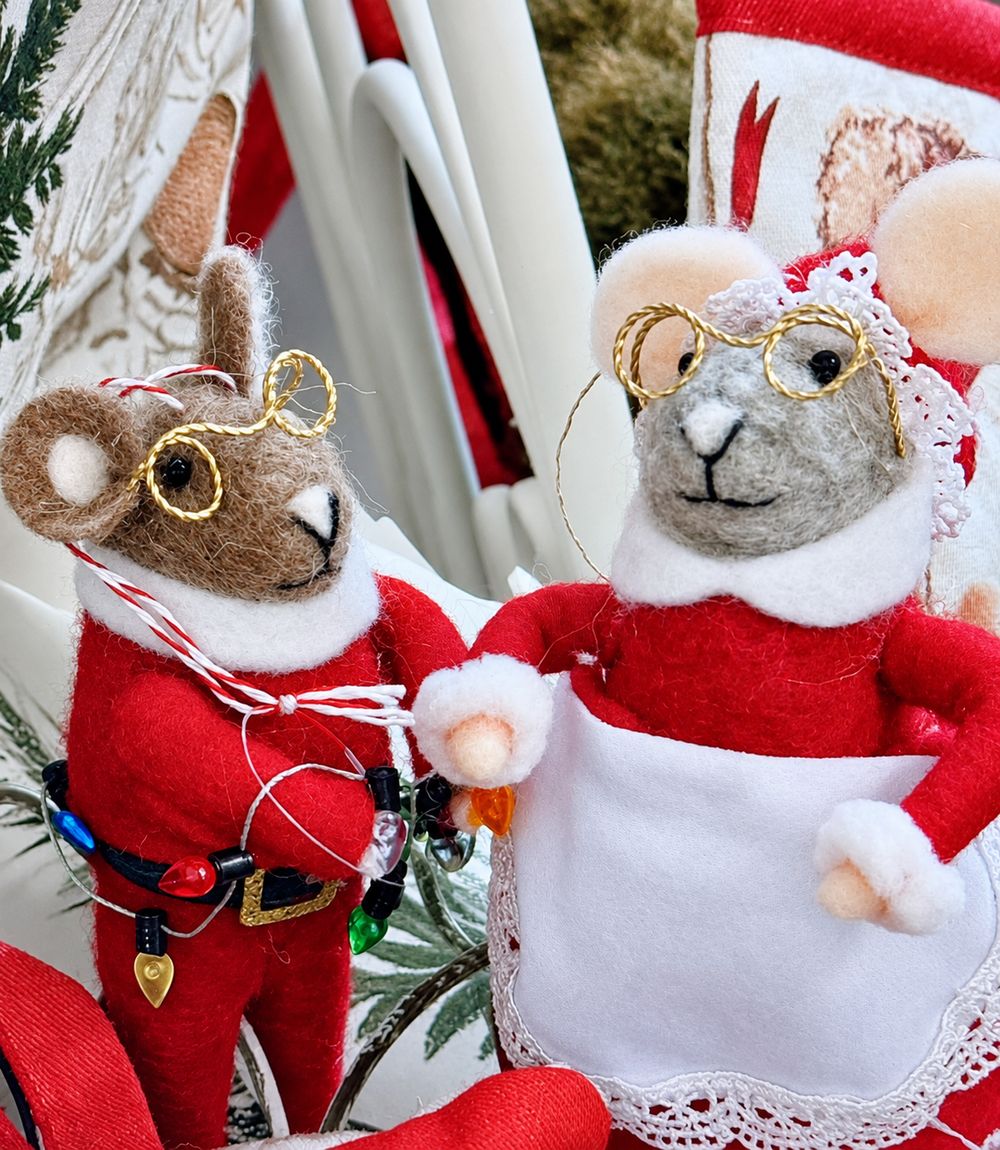 Gros plan sur les souris de Noël en feutrine, leurs lunettes dorées et le tablier blanc bordé de dentelle.