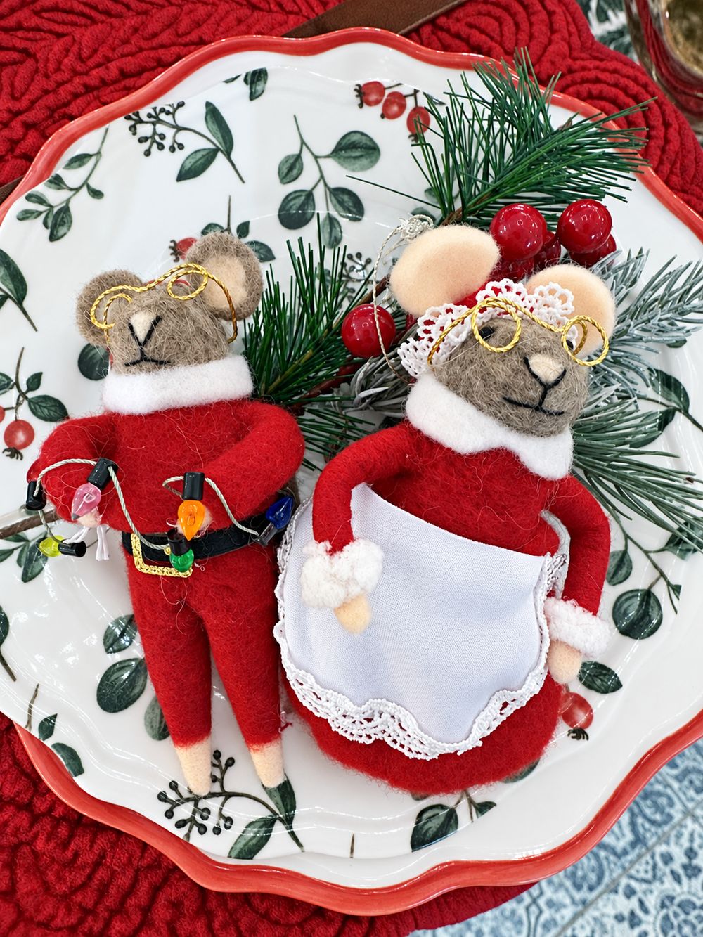 Vue de dessus du couple de souris de Noël en feutrine sur une assiette à motifs végétaux.