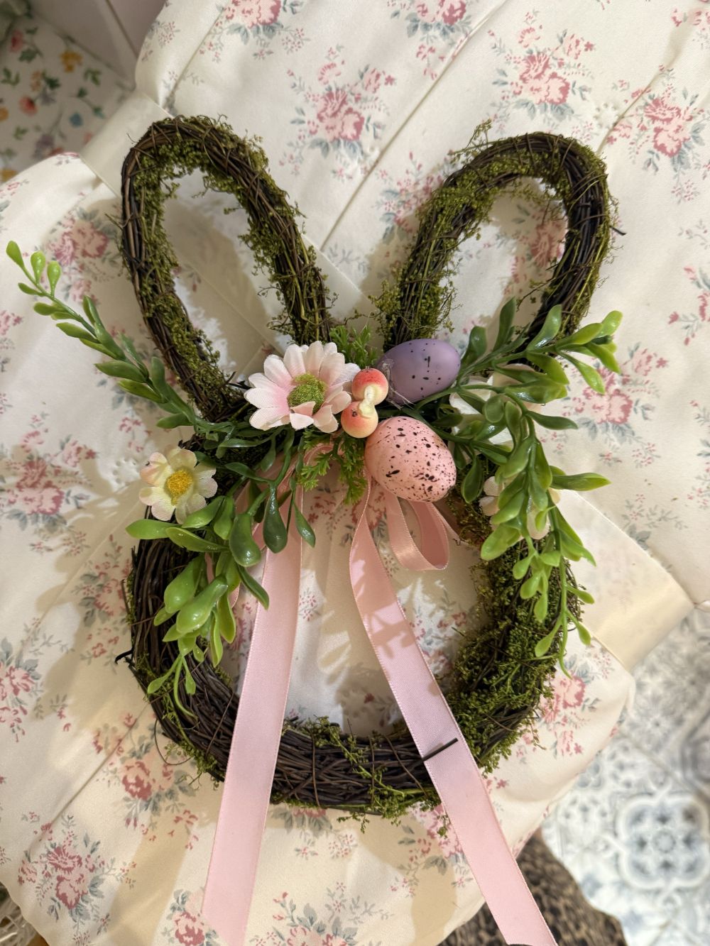 Couronne de Pâques en forme de lapin en osier brun, décorée de feuillage vert, fleurs roses, œufs pastel et rubans, style shabby chic romantique