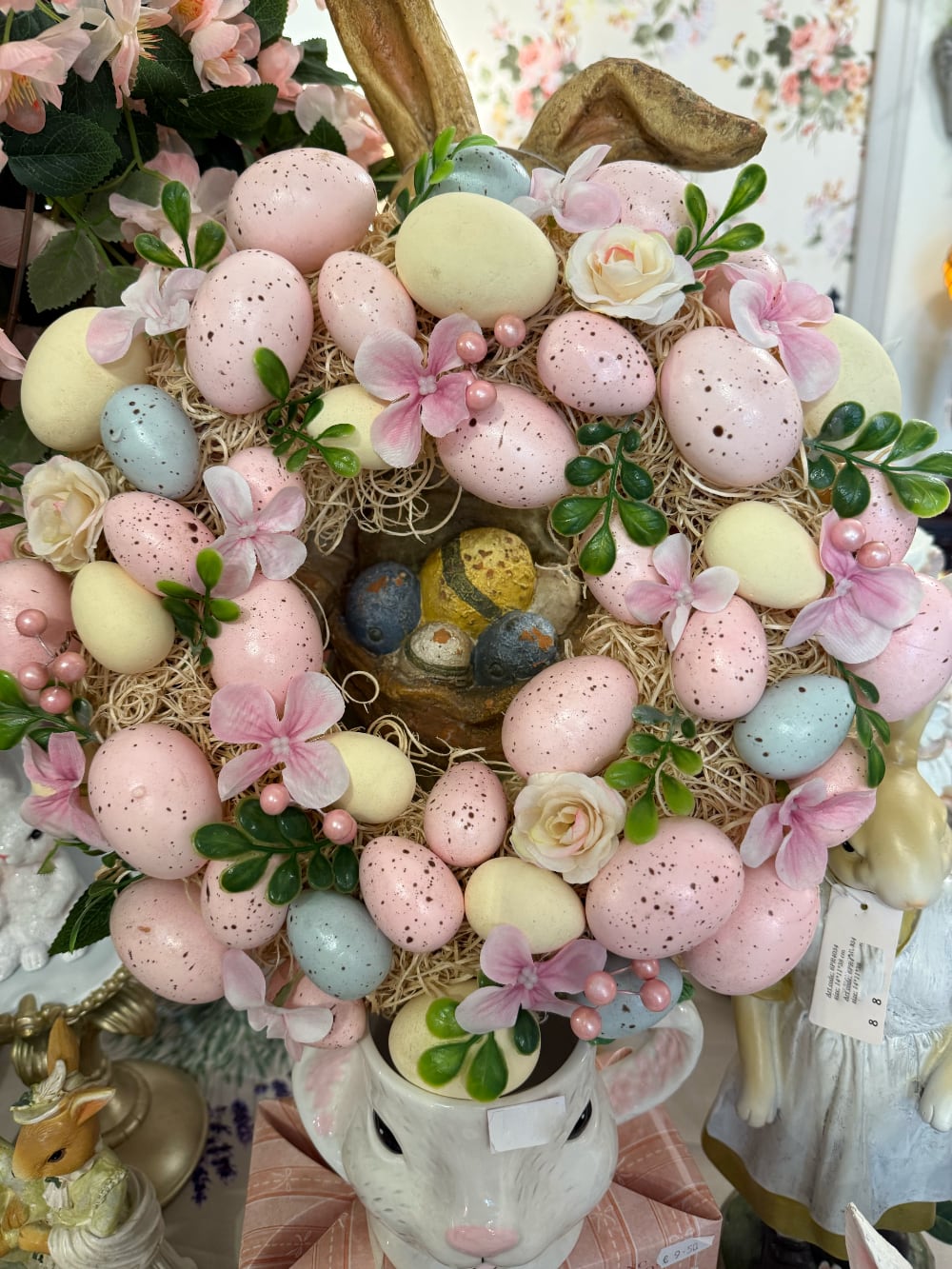 Couronne de Pâques décorative avec œufs pastel roses jaunes et bleus, fleurs et feuillage, style shabby chic romantique et printanier