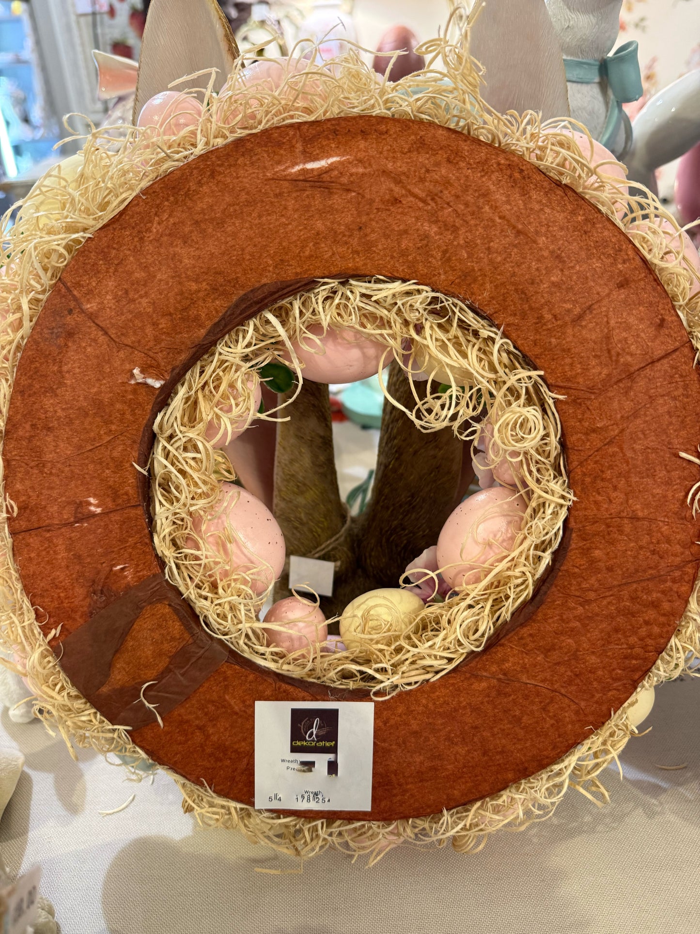 Couronne de Pâques décorative avec œufs pastel roses jaunes et bleus, fleurs et feuillage, style shabby chic romantique et printanier