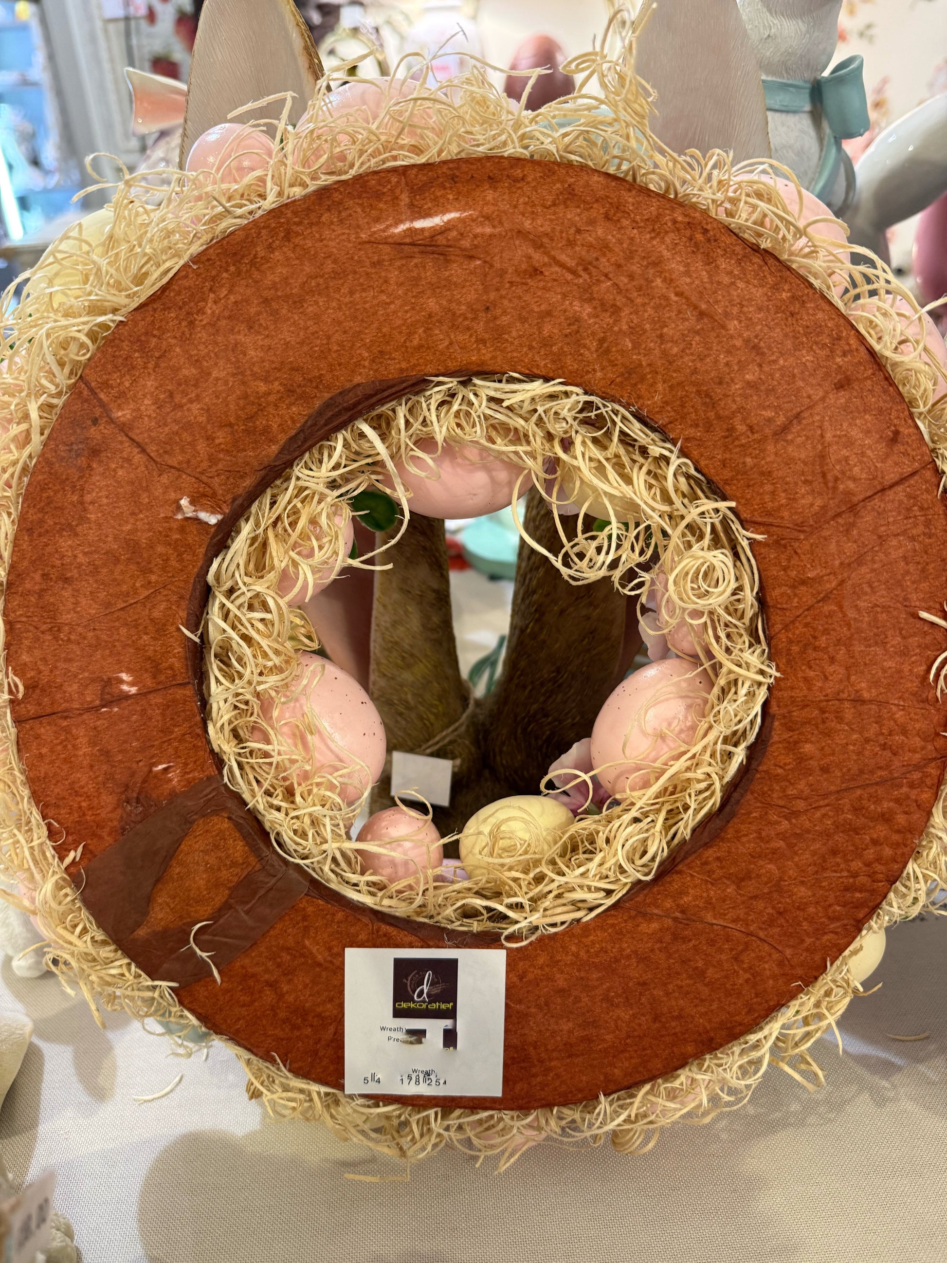 Couronne de Pâques décorative avec œufs pastel roses jaunes et bleus, fleurs et feuillage, style shabby chic romantique et printanier