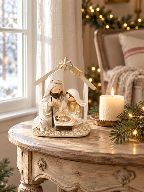 Petite crèche de Noël crème et dorée intégrée à une décoration de fête lumineuse.