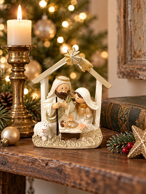 Petite crèche de Noël crème et dorée sur une étagère près du sapin.