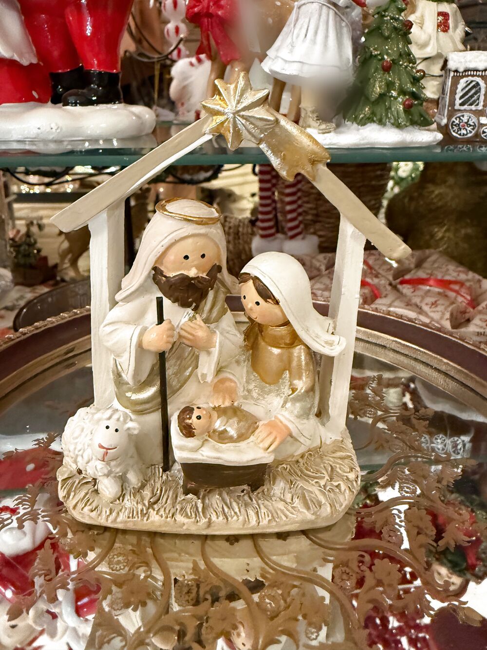 Petite crèche de Noël crème et dorée, vue de face entière de la Sainte Famille, de l’Enfant Jésus et du mouton.