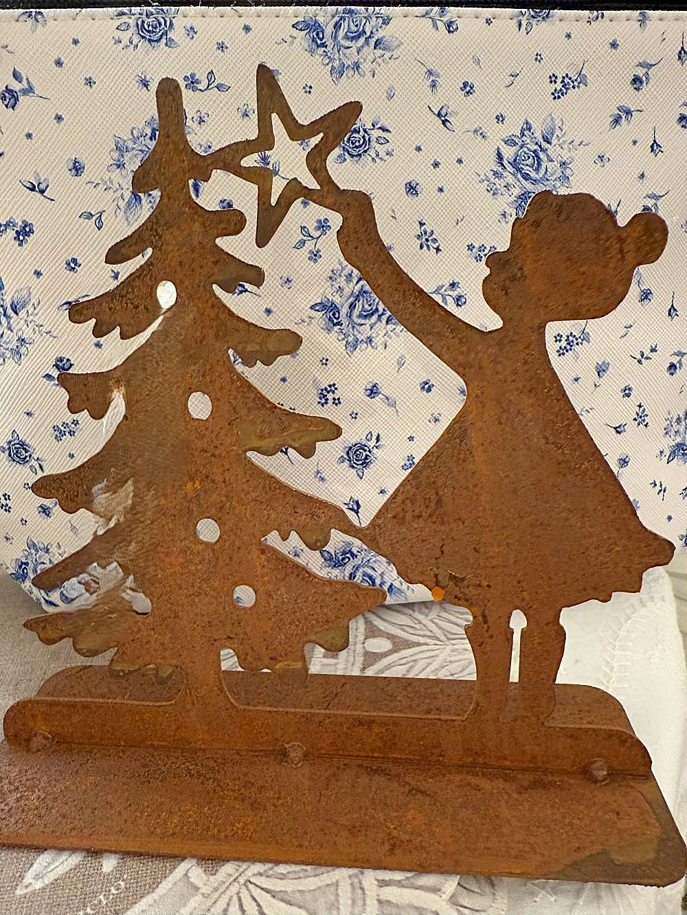 Décoration de Noël en métal rouillé représentant une petite fille plaçant une étoile sur un sapin, tons brun cuivre, style shabby chic et ambiance féérique