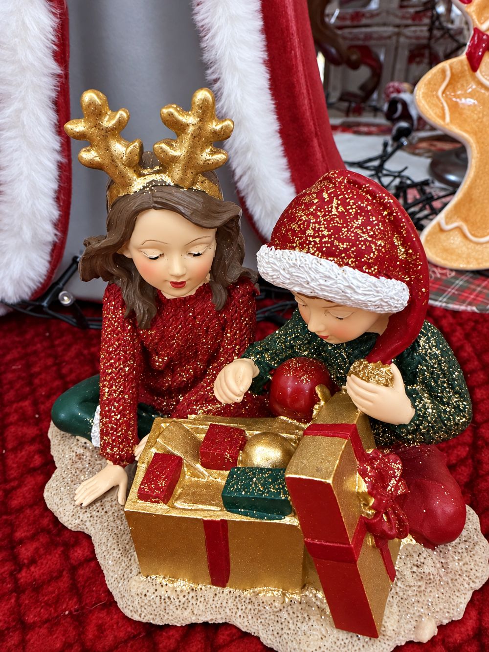 Vue plongeante des Enfants au Trésor de Noël et des petits cadeaux rouges et verts dans la boîte dorée.
