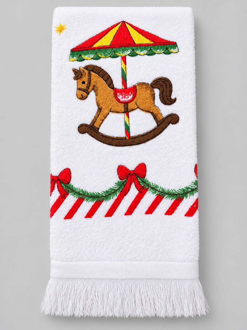 Essuie-main blanc à franges, motif cheval de carrousel et guirlandes de Noël, présenté plié sur fond gris clair.