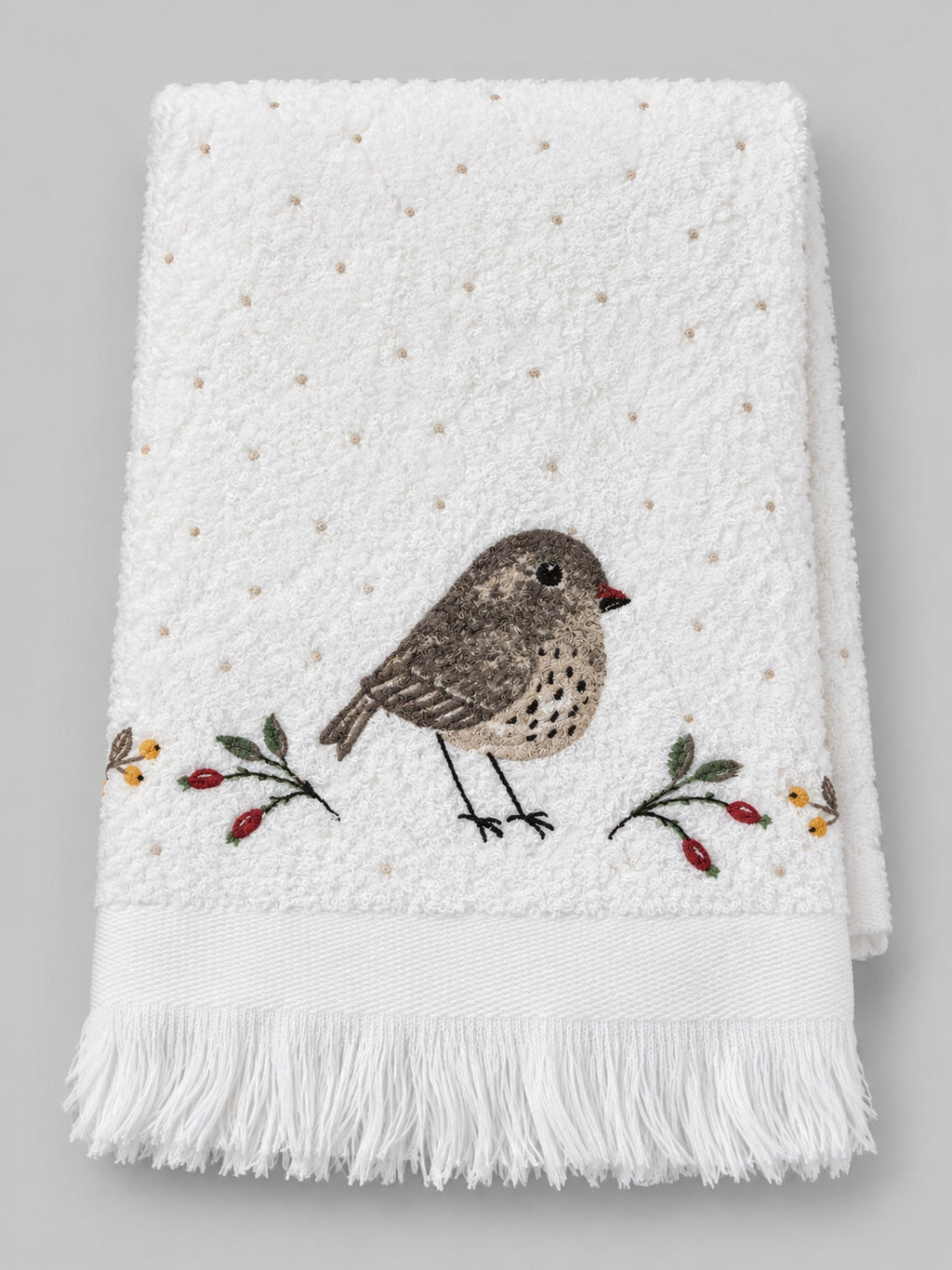 Essuie-mains Petit Oiseau plié, en coton blanc, avec oiseau brodé, branches à baies et franges.