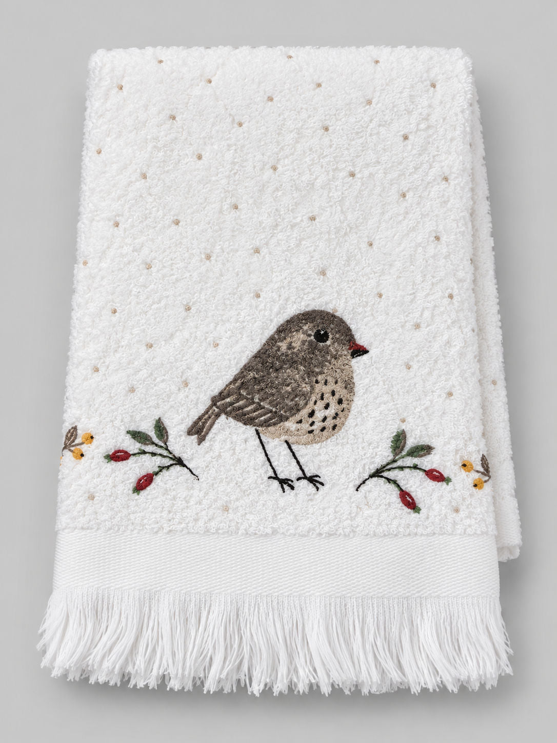 Essuie-mains Petit Oiseau plié, en coton blanc, avec oiseau brodé, branches à baies et franges.