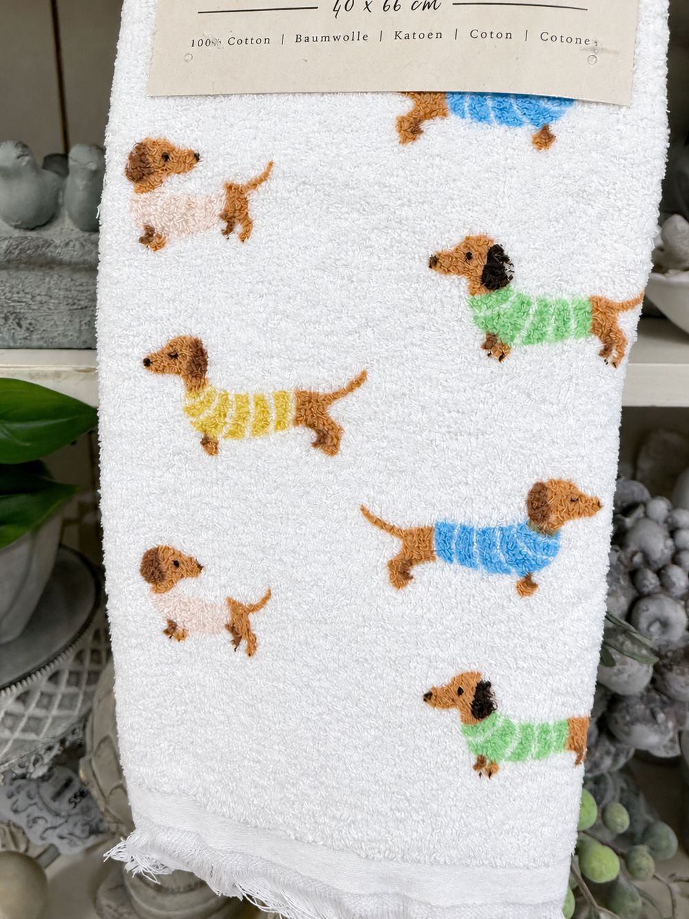 Détail du coton éponge blanc et des motifs de teckels aux pulls colorés.