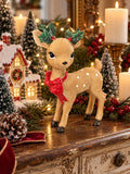 Faon Enchanté sur console de Noël avec sapins miniatures, maison illuminée et bougie