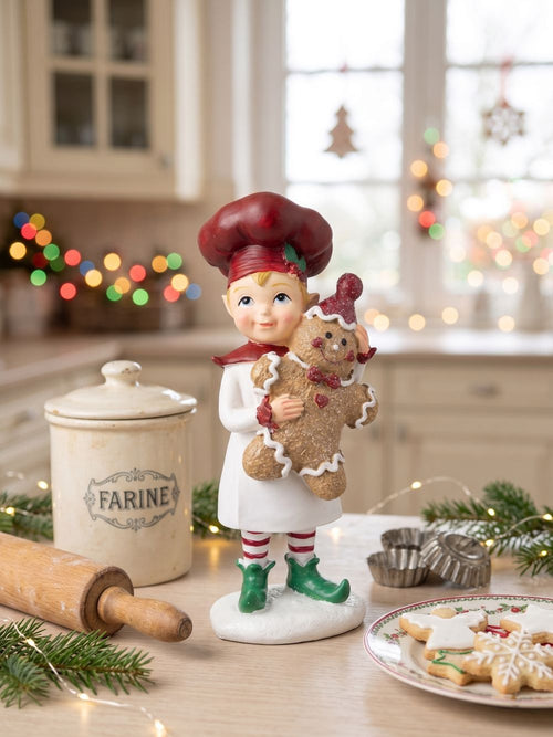Figurine farfadet de Noël rouge et crème tenant un bonhomme pain d’épices, décoration féérique à poser sur un buffet ou près du sapin