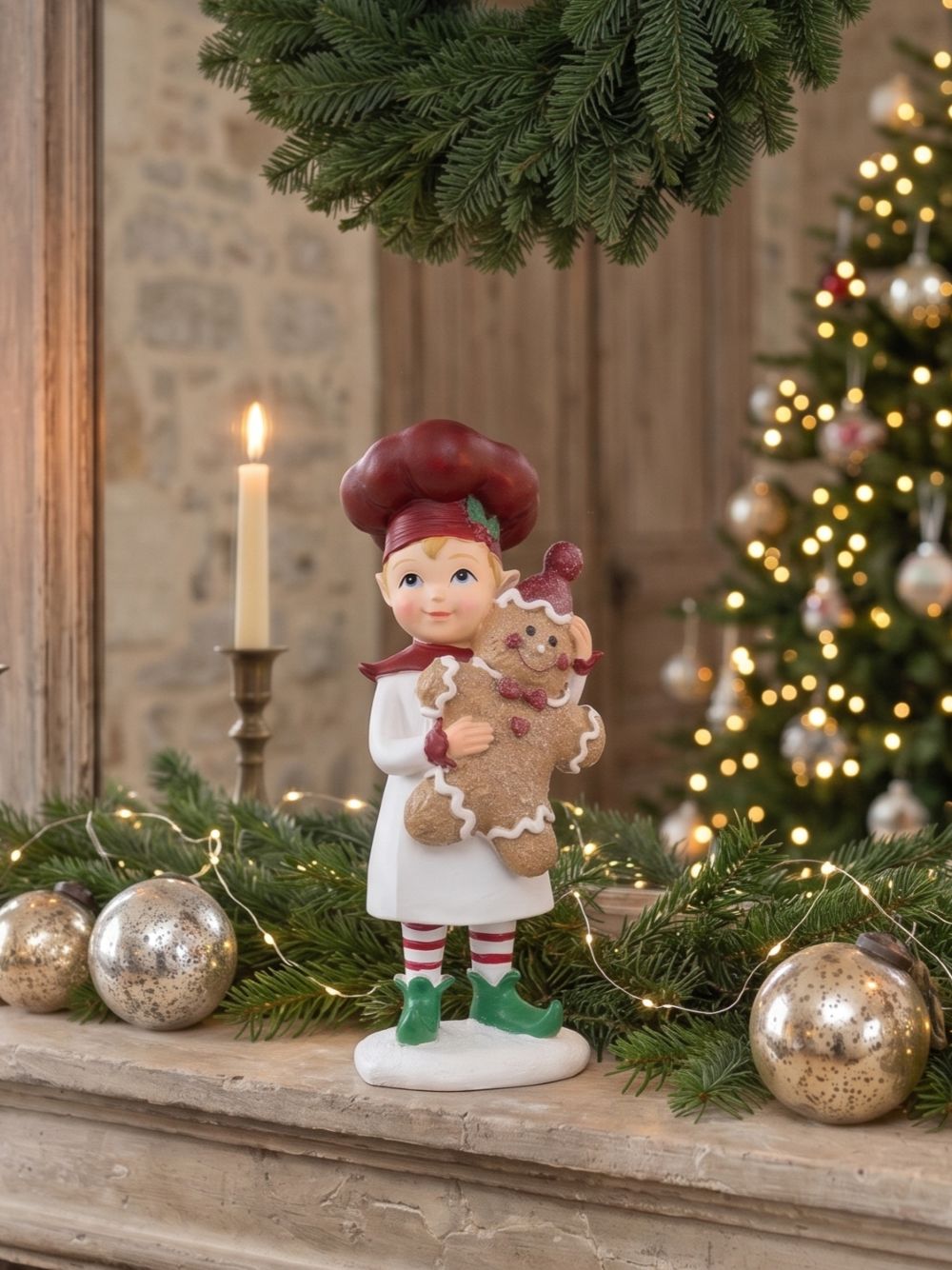Figurine farfadet de Noël rouge et crème tenant un bonhomme pain d’épices, décoration féérique à poser sur un buffet ou près du sapin