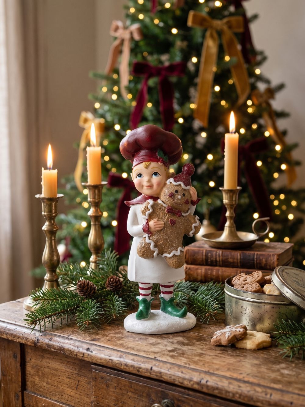 Figurine farfadet de Noël rouge et crème tenant un bonhomme pain d’épices, décoration féérique à poser sur un buffet ou près du sapin