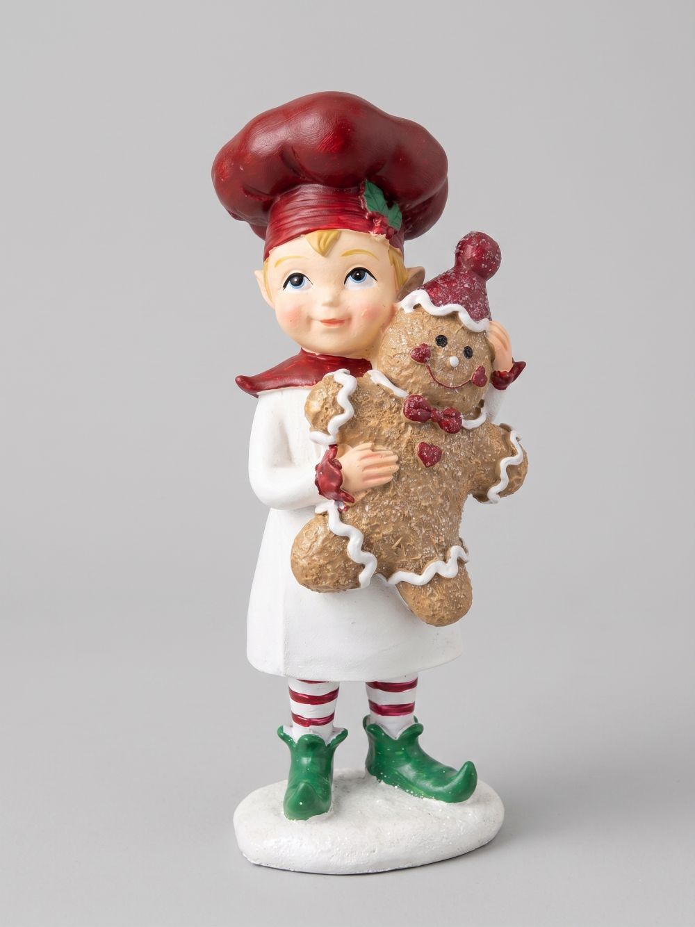 Figurine farfadet de Noël rouge et crème tenant un bonhomme pain d’épices, décoration féérique à poser sur un buffet ou près du sapin