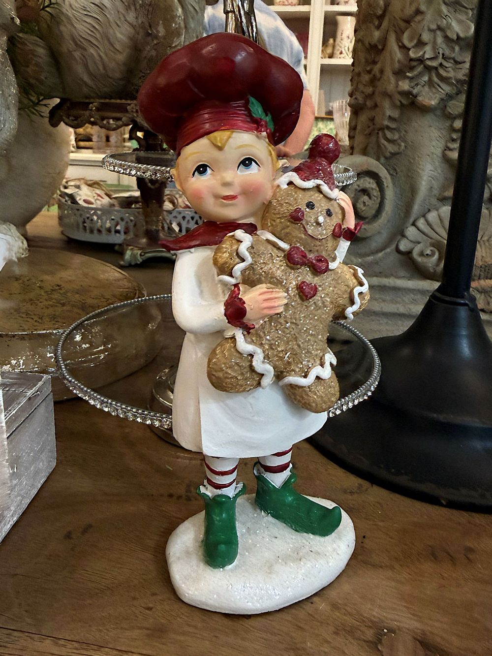 Figurine farfadet de Noël rouge et crème tenant un bonhomme pain d’épices, décoration féérique à poser sur un buffet ou près du sapin