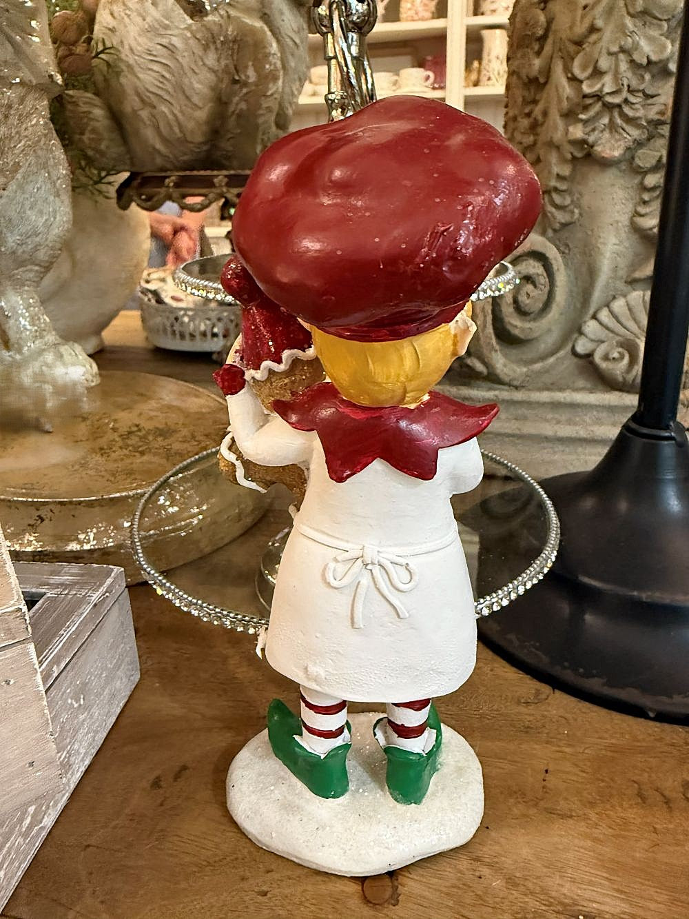Figurine farfadet de Noël rouge et crème tenant un bonhomme pain d’épices, décoration féérique à poser sur un buffet ou près du sapin