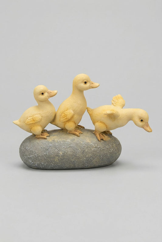 Figurine décorative de trois petits canards jaunes sur socle effet pierre, ambiance printanière et romantique avec fleurs, style shabby chic et décoration de charme
