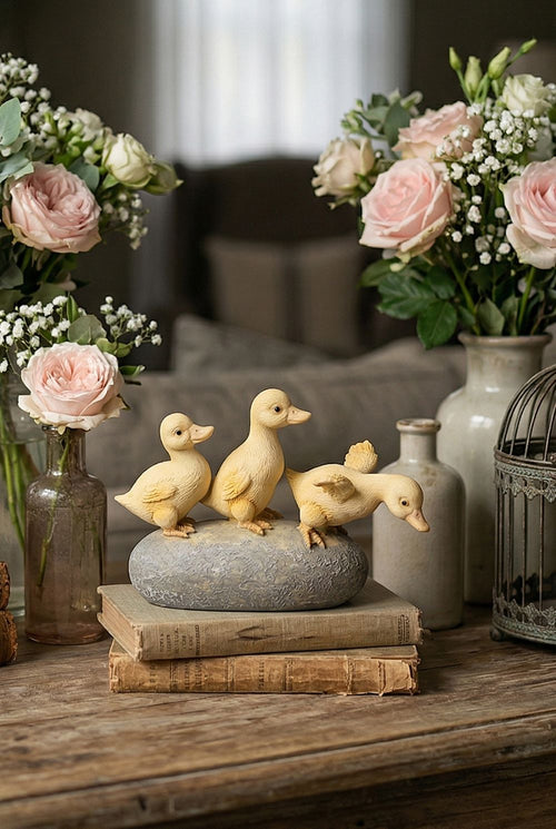 Figurine décorative de trois petits canards jaunes sur socle effet pierre, ambiance printanière et romantique avec fleurs, style shabby chic et décoration de charme