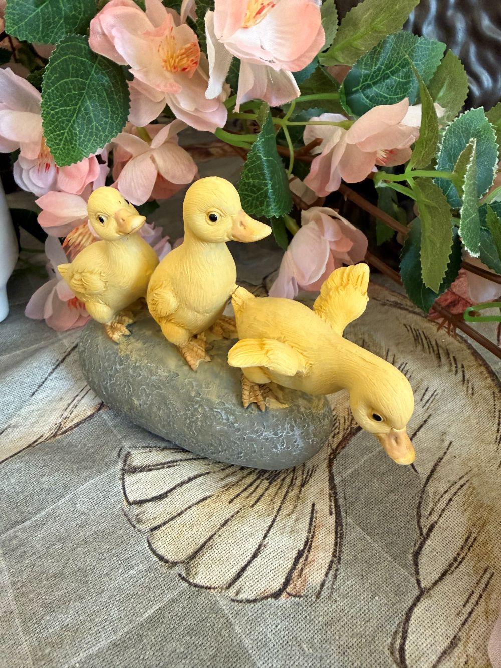 Figurine décorative de trois petits canards jaunes sur socle effet pierre, ambiance printanière et romantique avec fleurs, style shabby chic et décoration de charme