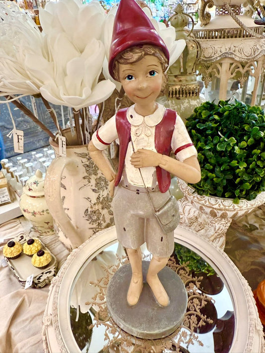 Figurine déco de Pinocchio en posture de marche, couleurs rouge bordeaux, beige et gris clair, style poétique et shabby chic, compagnon de balade au charme romantique