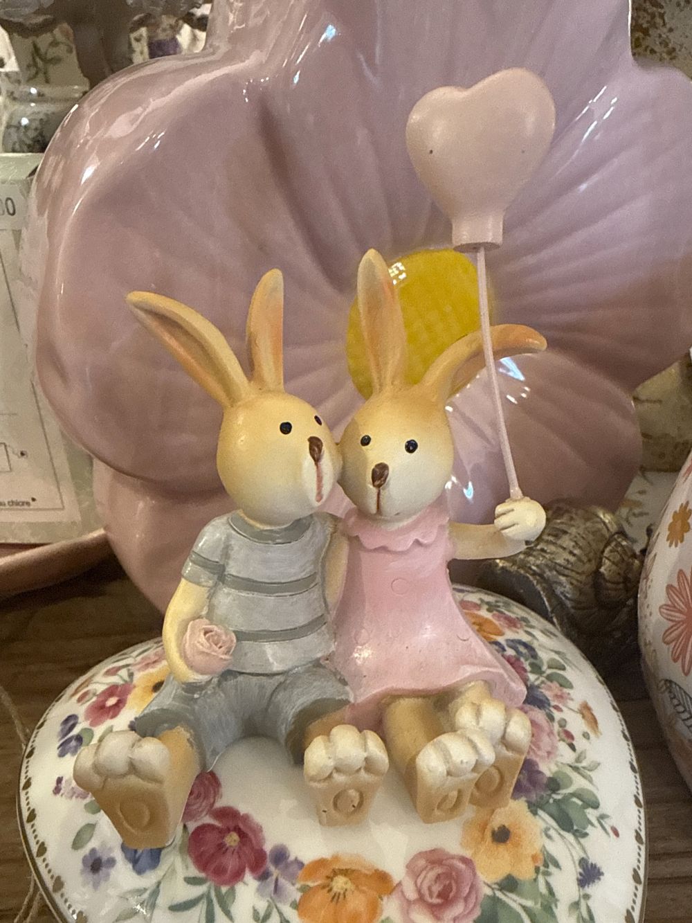 Figurine décorative duo de lapins enlacés avec ballon cœur rose, tons rose poudré et gris, style shabby chic romantique et féérique, ambiance décoration de charme.