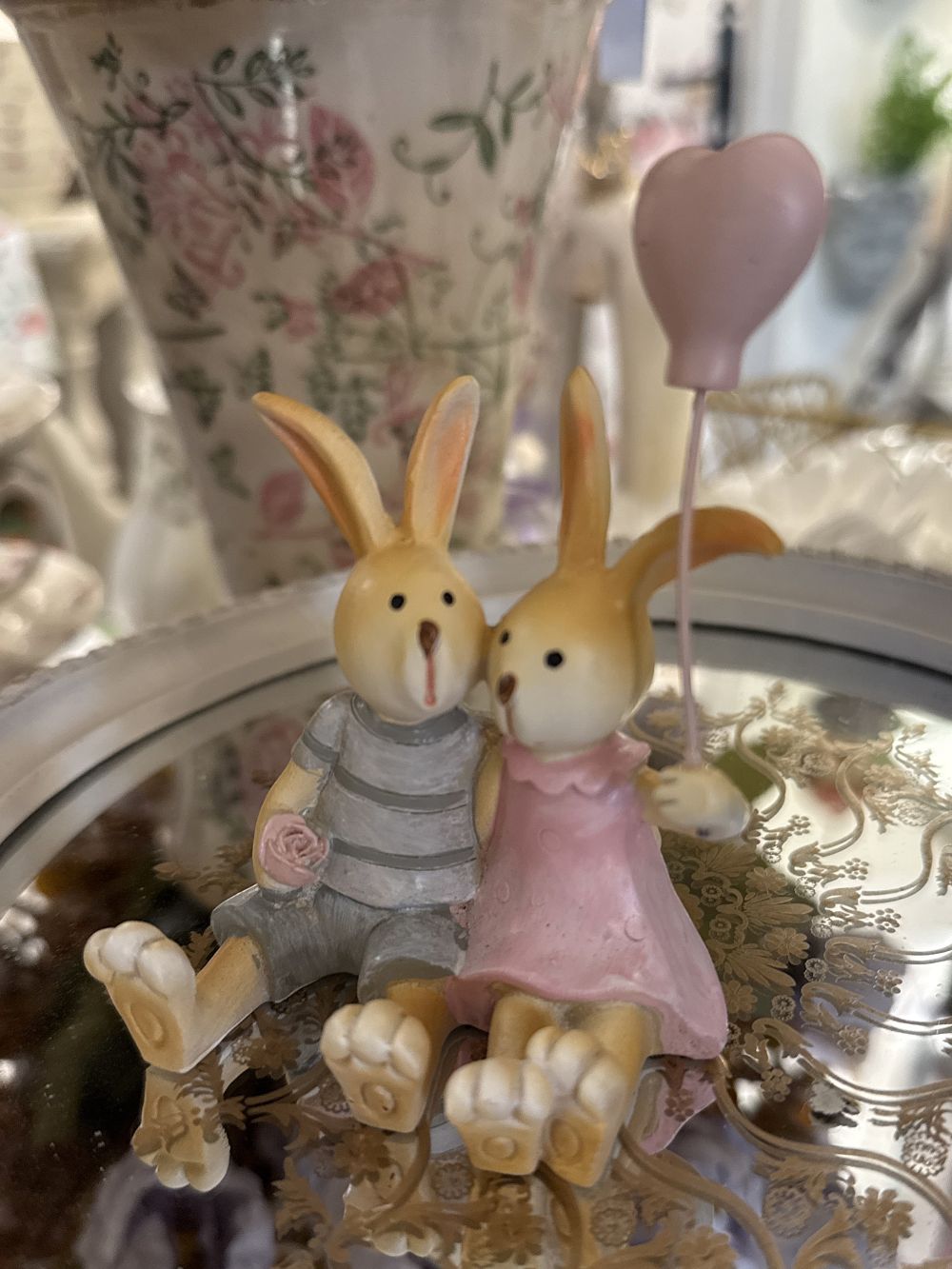 Figurine décorative duo de lapins enlacés avec ballon cœur rose, tons rose poudré et gris, style shabby chic romantique et féérique, ambiance décoration de charme.
