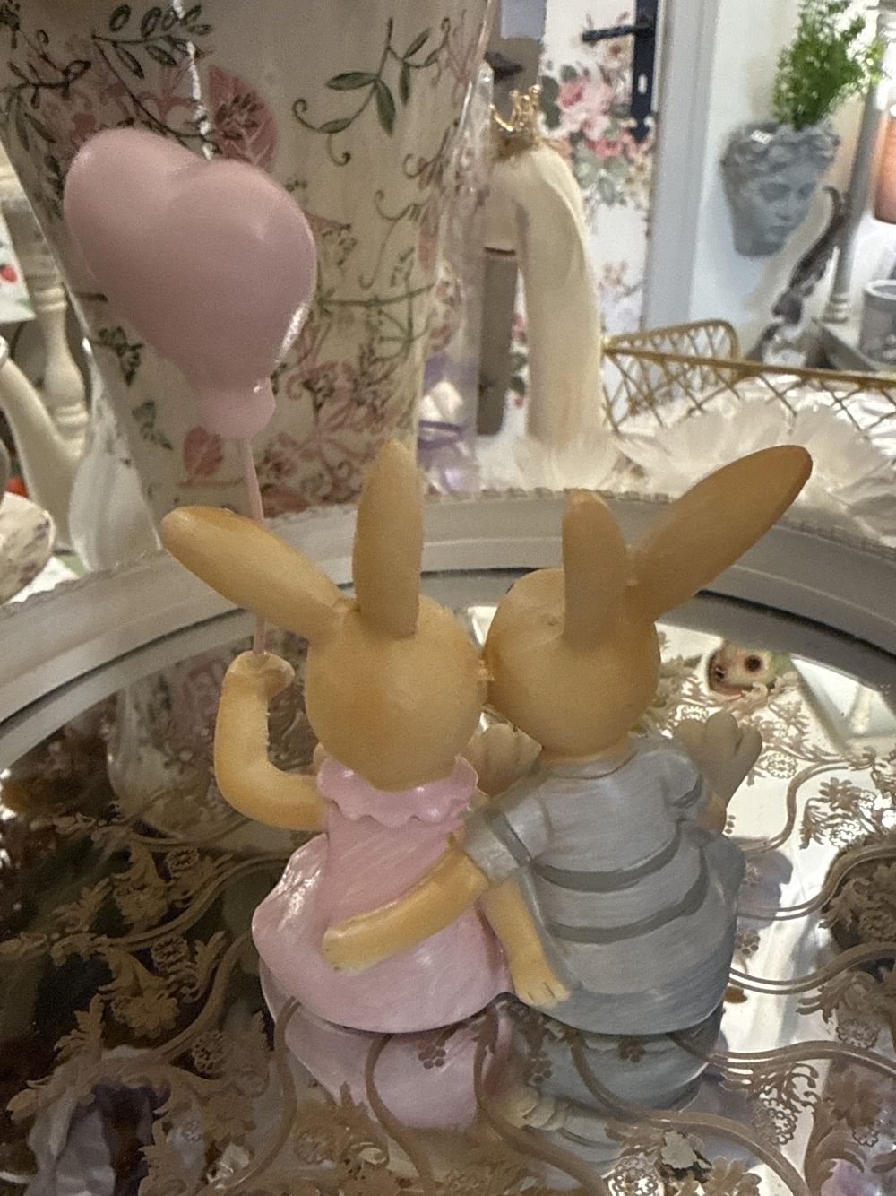 Figurine décorative duo de lapins enlacés avec ballon cœur rose, tons rose poudré et gris, style shabby chic romantique et féérique, ambiance décoration de charme.