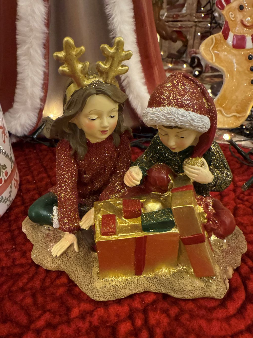 Figurine décorative représentant deux enfants avec des cadeaux de Noël, tons rouge or et vert, style féérique et romantique, décoration de charme shabby chic