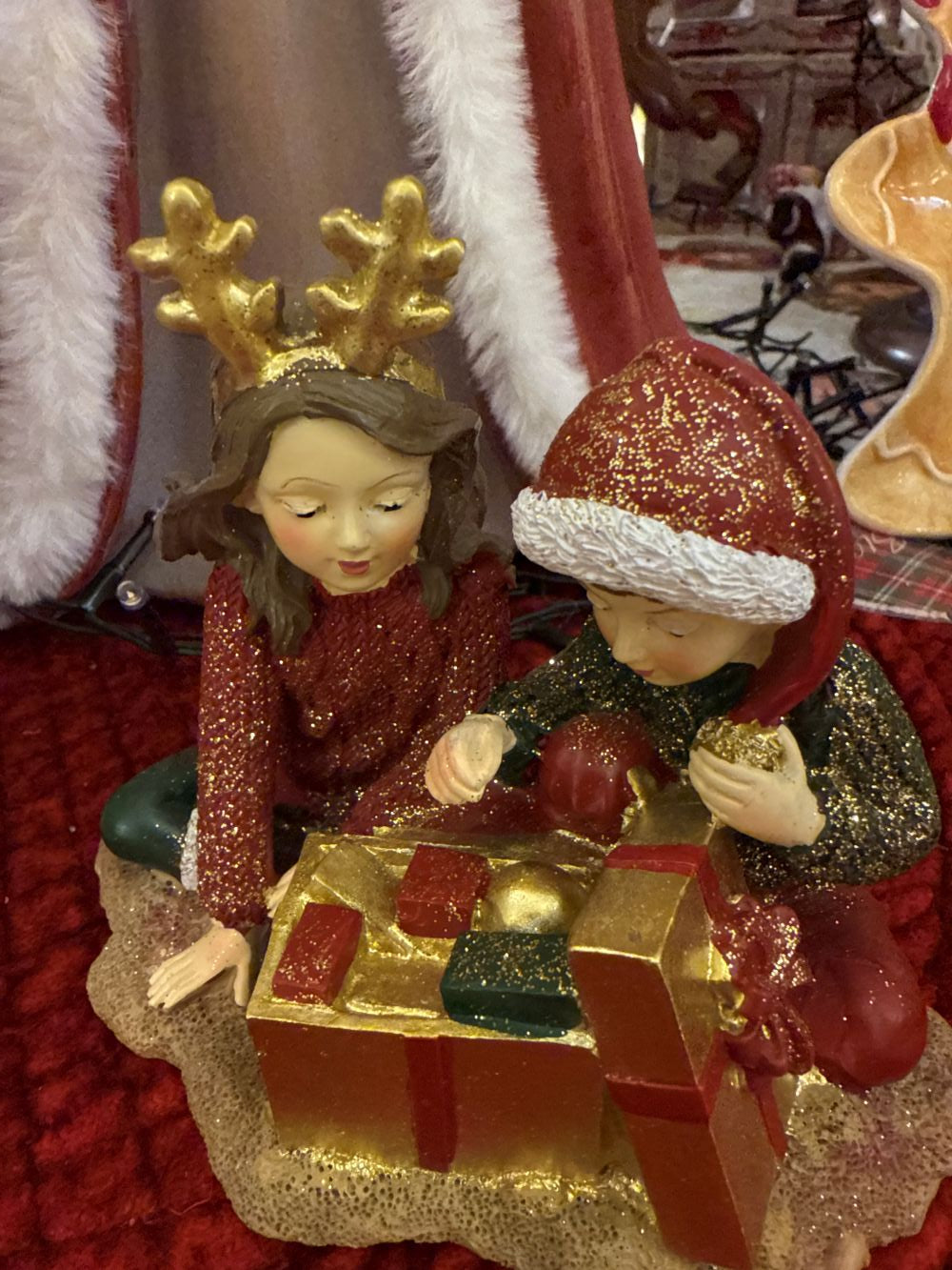 Figurine décorative représentant deux enfants avec des cadeaux de Noël, tons rouge or et vert, style féérique et romantique, décoration de charme shabby chic