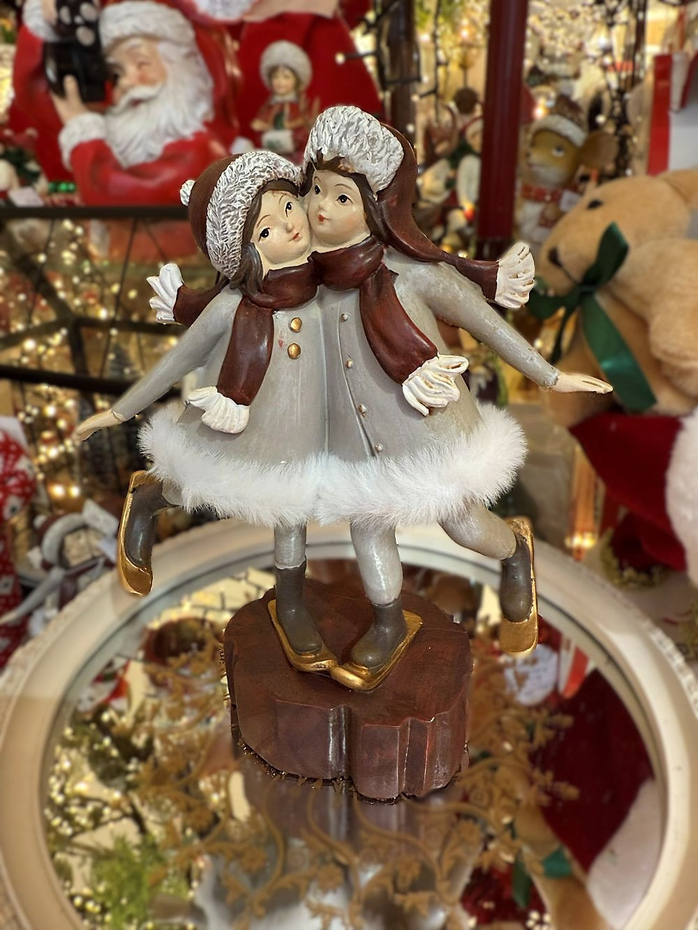 Figurine de Noël représentant deux petites skieuses en gris, blanc et marron, sur socle bois, ambiance hivernale romantique et féérique