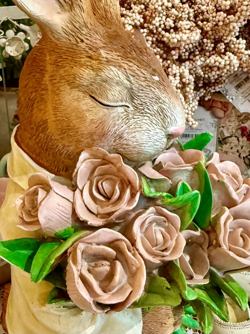Figurine décorative représentant un lapin marron tenant un bouquet de roses rose pastel avec feuillage vert, dans un style shabby chic romantique et poétique
