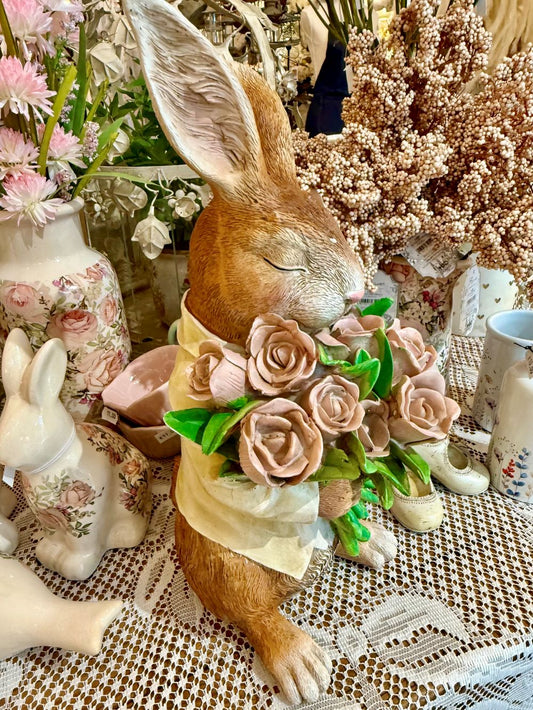 Figurine décorative représentant un lapin marron tenant un bouquet de roses rose pastel avec feuillage vert, dans un style shabby chic romantique et poétique