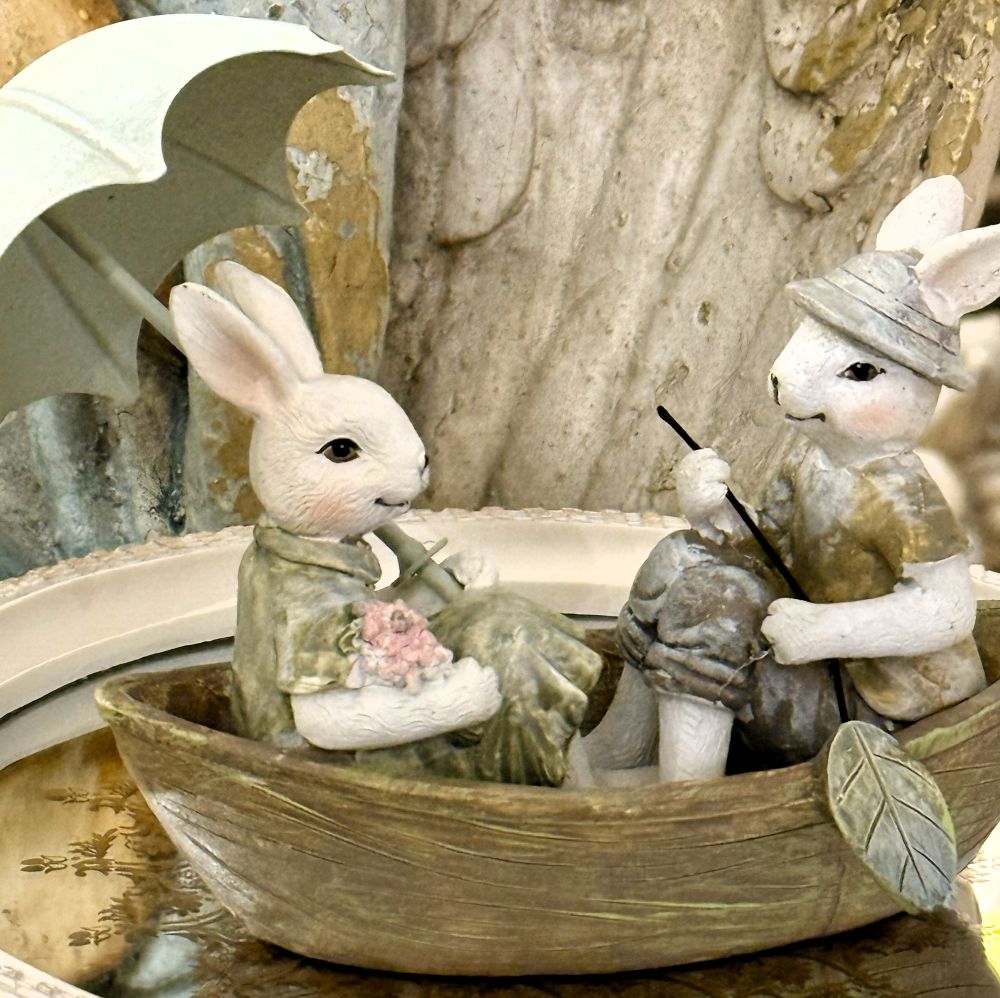 Figurine décorative représentant deux lapins en barque avec ombrelle, tons blanc beige et vert patiné, style shabby chic, ambiance romantique et féérique, décoration poétique de charme