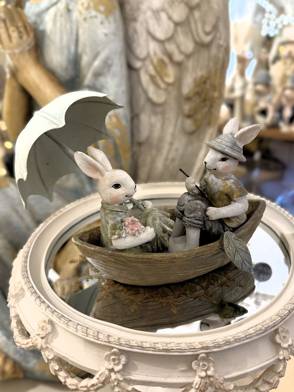 Figurine décorative représentant deux lapins en barque avec ombrelle, tons blanc beige et vert patiné, style shabby chic, ambiance romantique et féérique, décoration poétique de charme