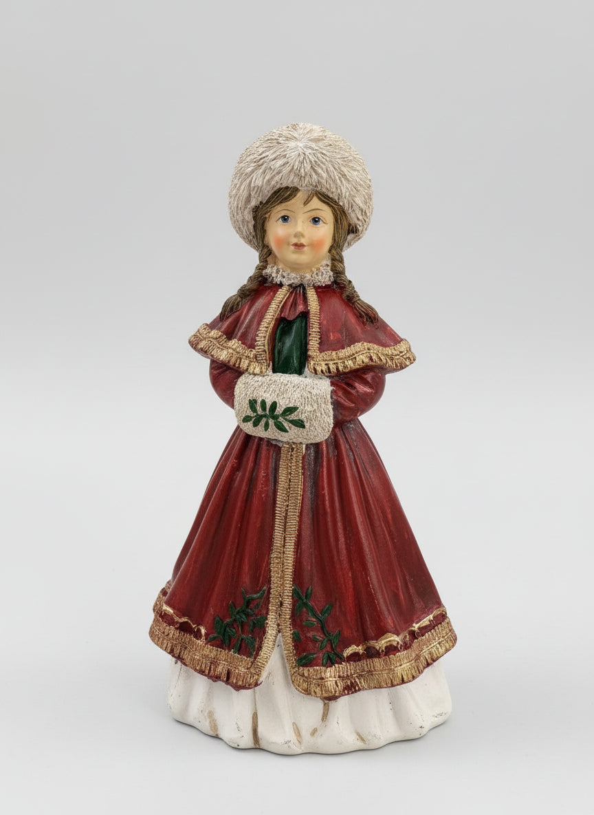 Figurine matriochka décorative en manteau rouge avec bonnet blanc, détails dorés et style hivernal féérique, posée dans une ambiance de Noël chaleureuse