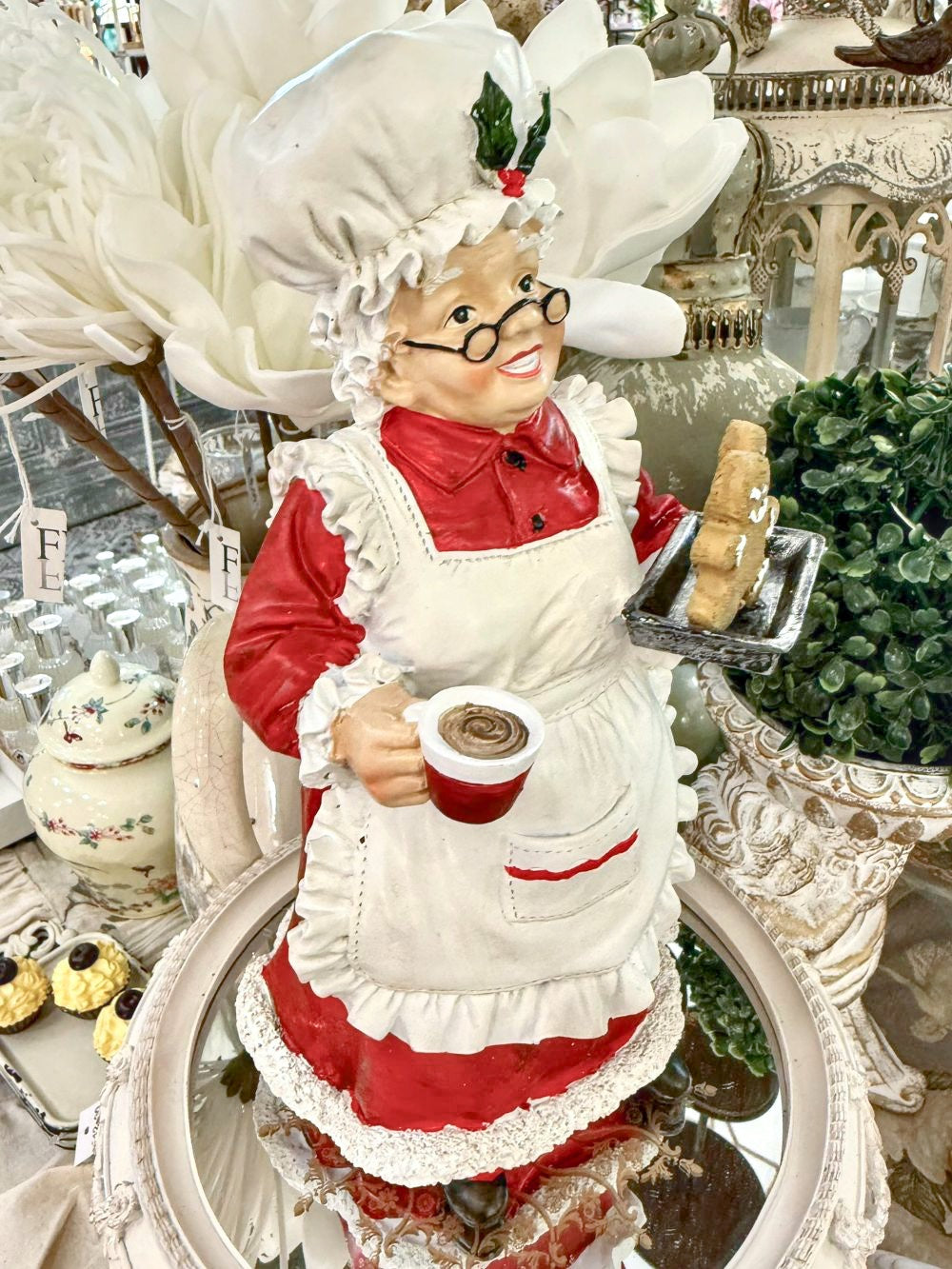 Figurine décorative de 30 cm représentant la Mère Noël en tenue de pâtissière rouge et blanche, tenant une tasse et un biscuit pain d’épices, style vintage et féérique