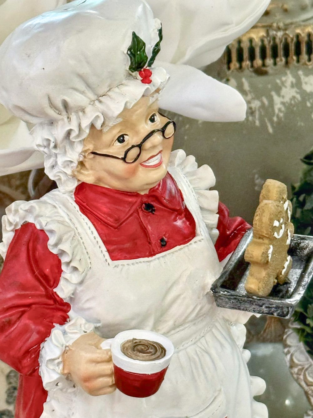 Figurine décorative de 30 cm représentant la Mère Noël en tenue de pâtissière rouge et blanche, tenant une tasse et un biscuit pain d’épices, style vintage et féérique