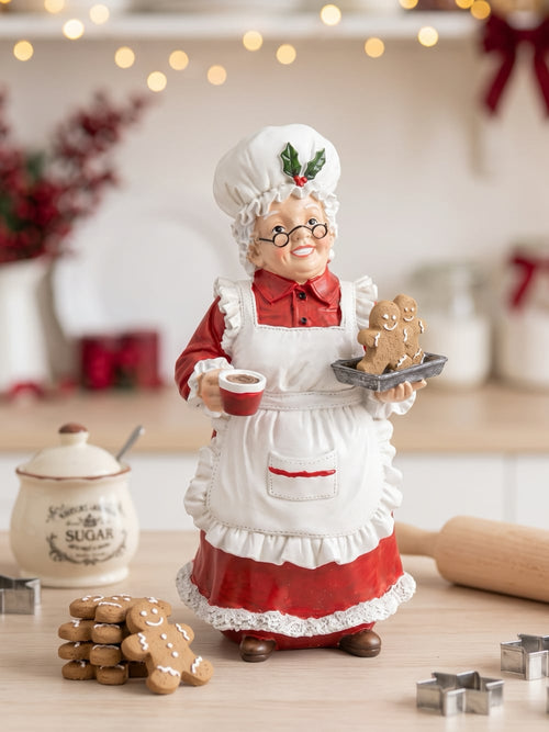 Figurine décorative de 30 cm représentant la Mère Noël en tenue de pâtissière rouge et blanche, tenant une tasse et un biscuit pain d’épices, style vintage et féérique