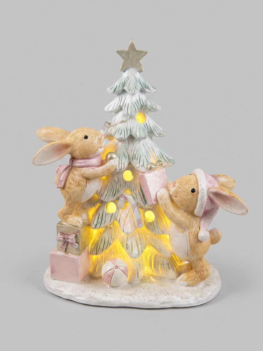 Figurine de Noël avec deux lapinous autour d’un sapin lumineux, tons vert givré, crème et rose poudré, décoration féérique et romantique