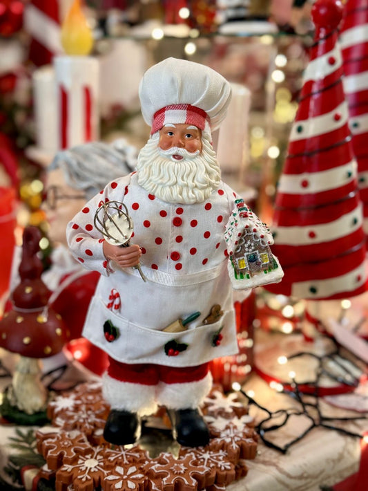 Figurine Père Noël Pâtissier 28 cm en rouge et blanc, tenant un fouet et une maison en pain d’épices, style shabby chic et féérique pour décoration de Noël