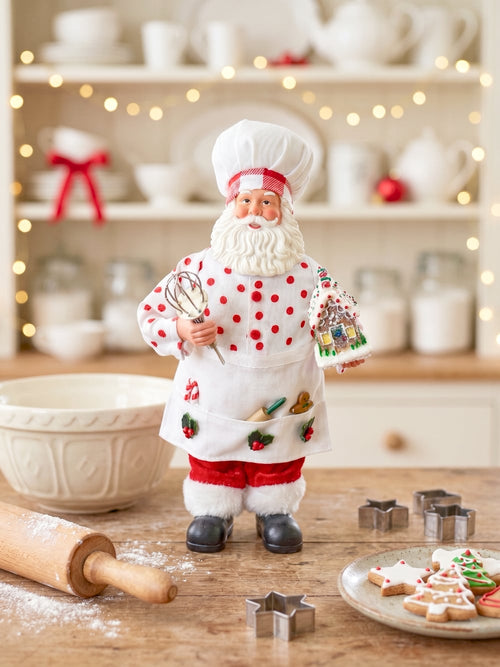 Figurine Père Noël Pâtissier 28 cm en rouge et blanc, tenant un fouet et une maison en pain d’épices, style shabby chic et féérique pour décoration de Noël