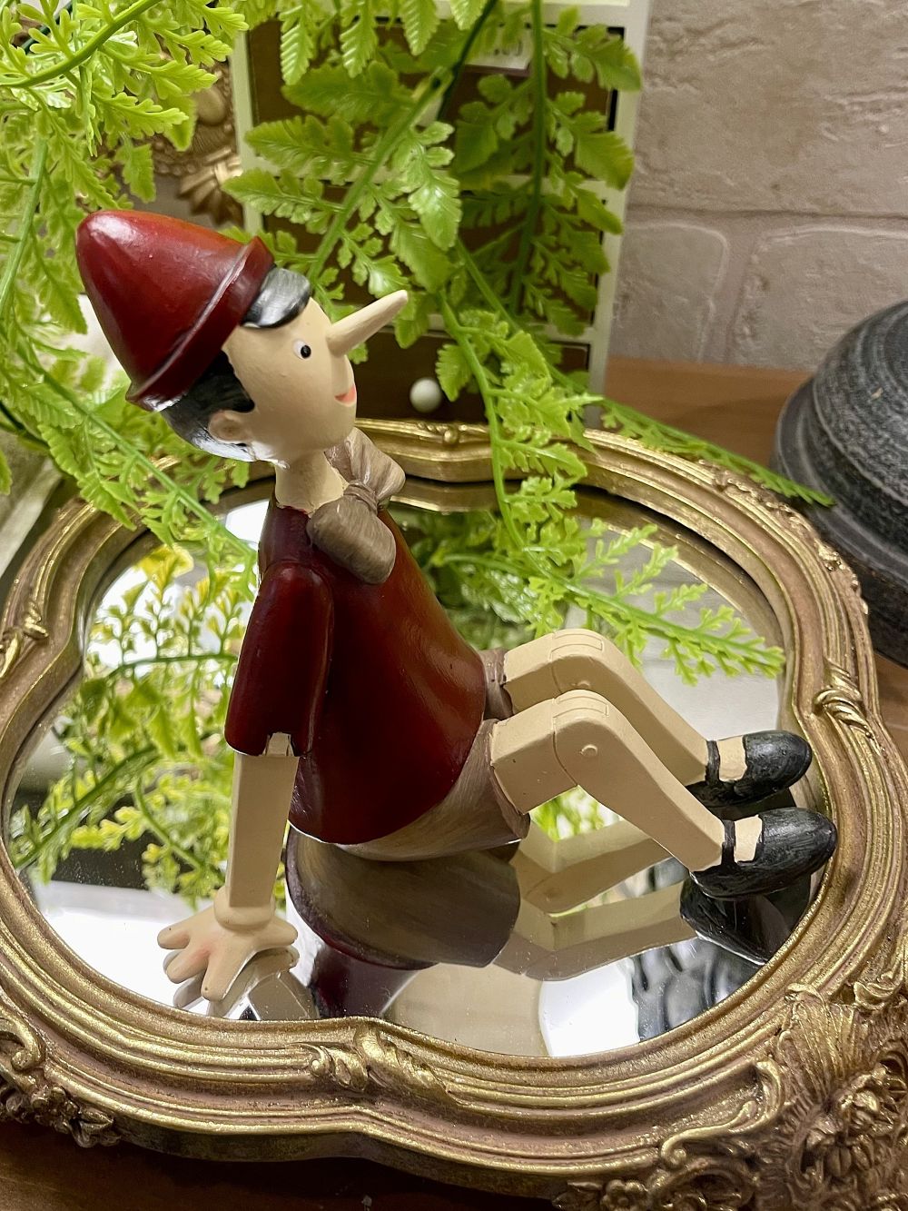 Figurine Pinocchio assis rouge beige marron style décoration romantique et vintage