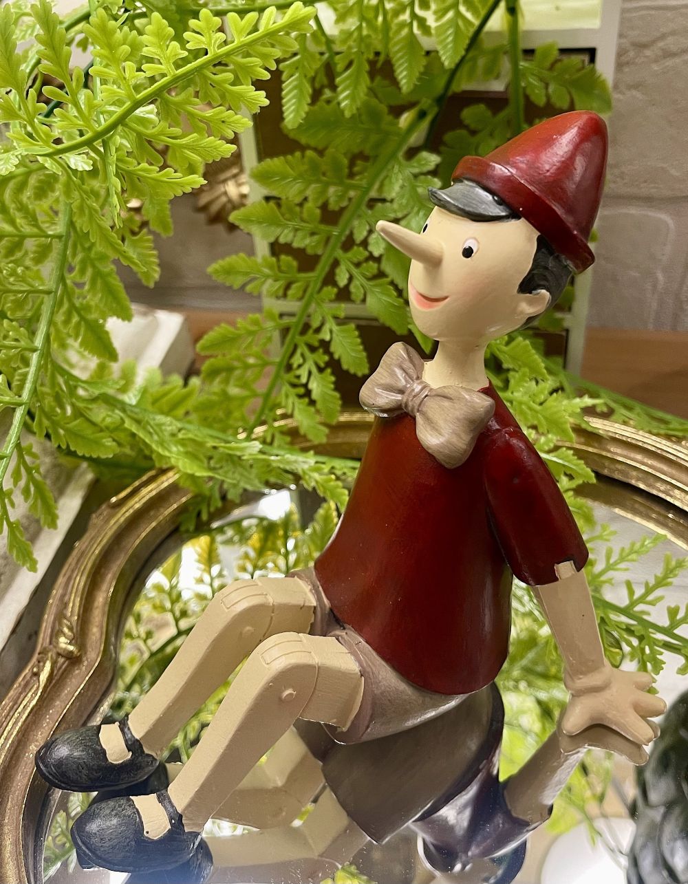 Figurine Pinocchio assis rouge beige marron style décoration romantique et vintage