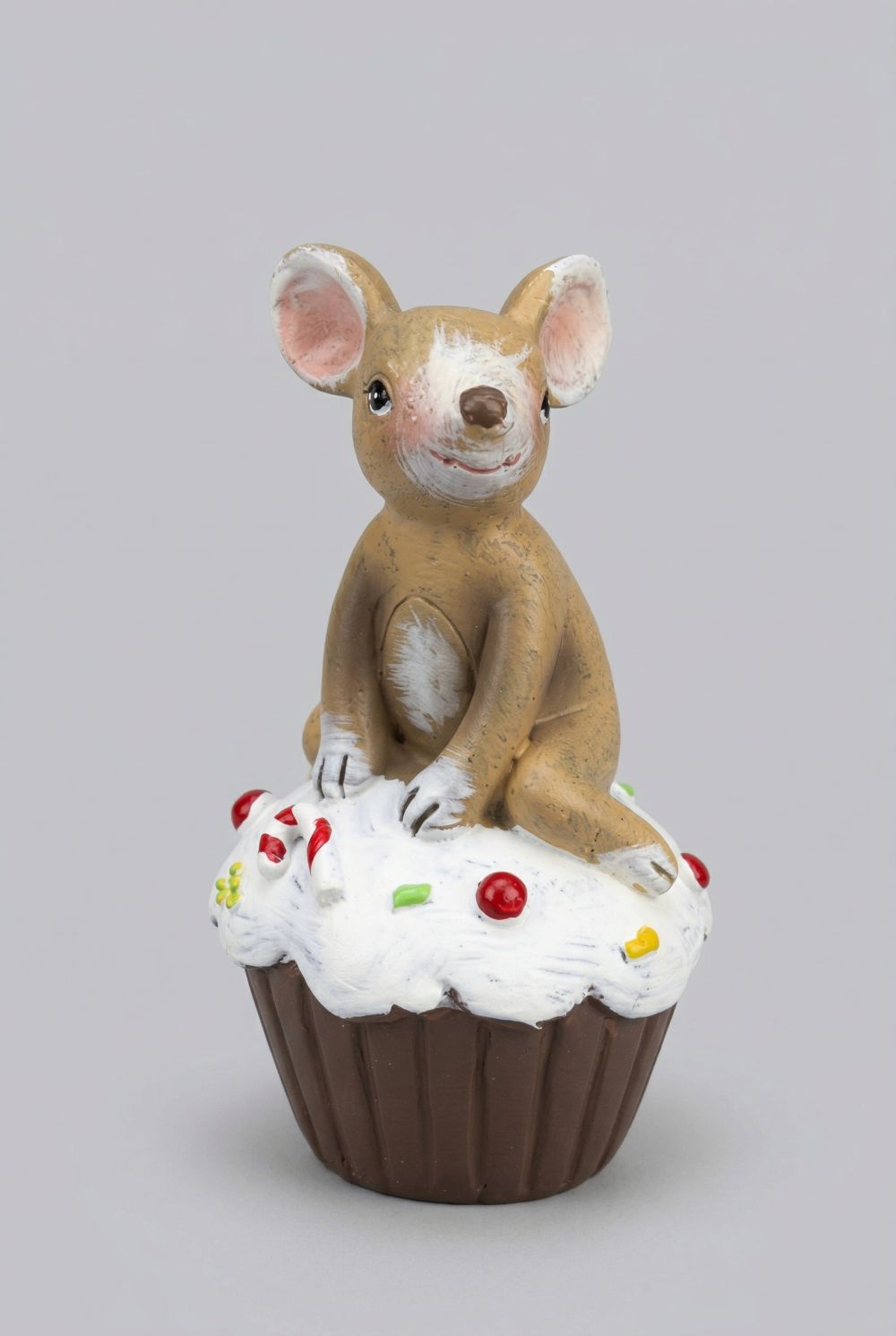Figurine souris beige assise sur un cupcake blanc décoré, ambiance romantique shabby chic et décoration printanière pleine de charme