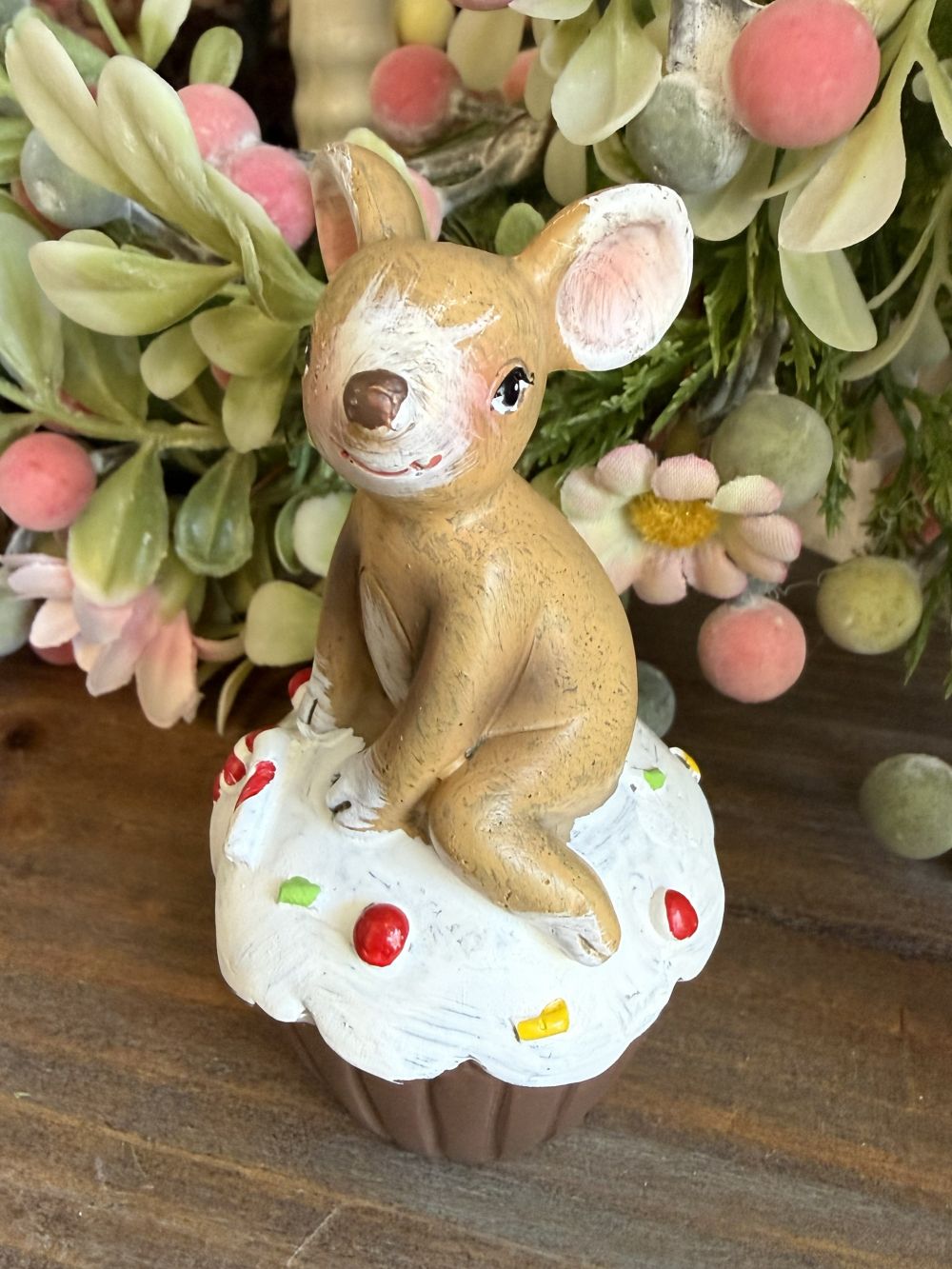 Figurine souris beige assise sur un cupcake blanc décoré, ambiance romantique shabby chic et décoration printanière pleine de charme
